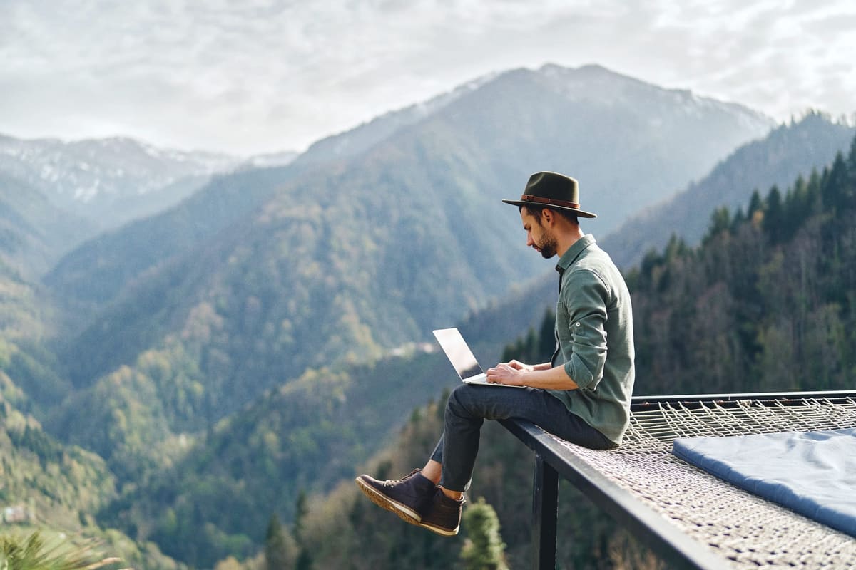 Working on a laptop from a high mountain terrace